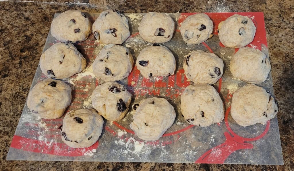 16 balls of dough on a floured cutting board.