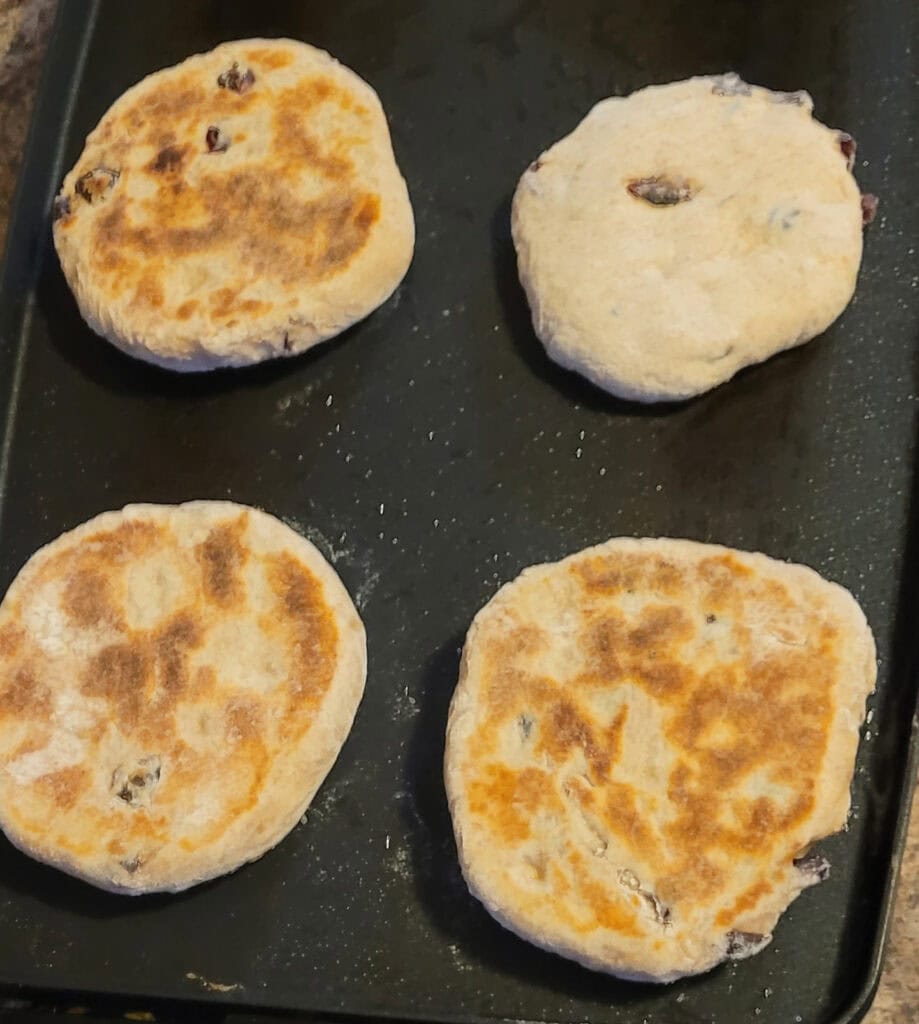 Flat breads cooking on a flat top grill. 3 of them have been flipped already.