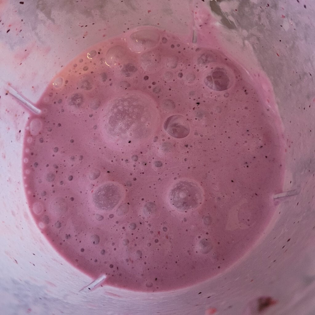 Purple liquid in the bottom of a blender, from blending frozen strawberries, blueberries and bananas with milk and yogurt.